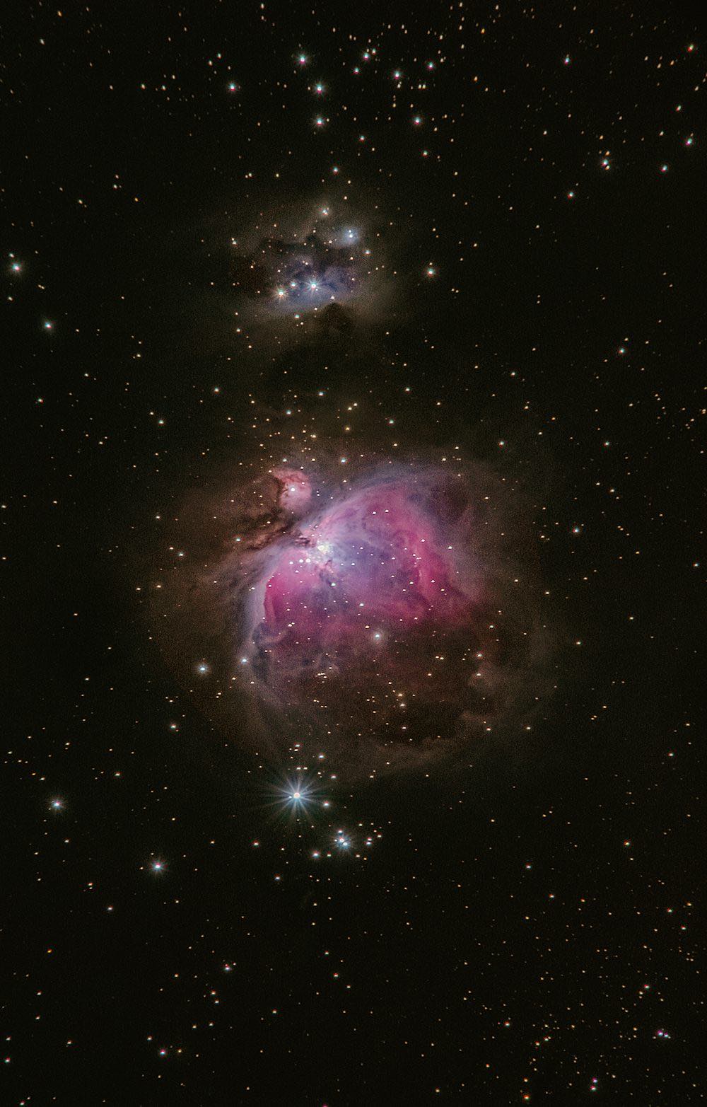 A glowing nebula of coloured gas and dust surrounded by scattered stars.