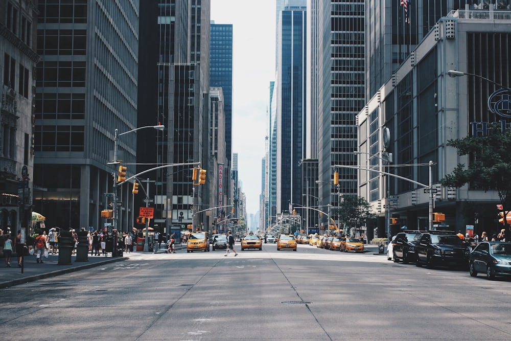 A long straight city street lined with tall buildings, traffic receding into the distance.